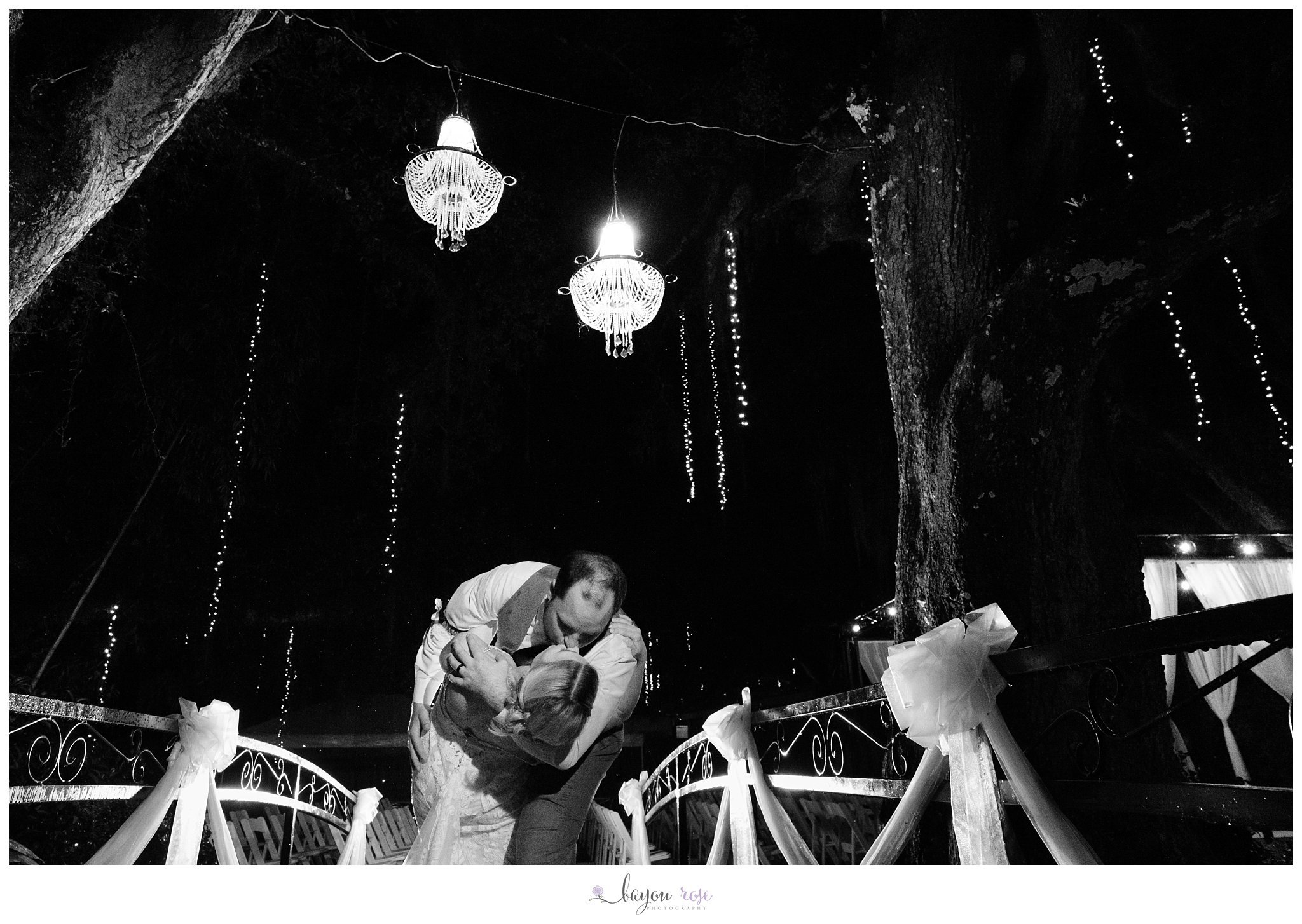 groom dipping bride under chandelier at The Oaks in Ponchatoula
