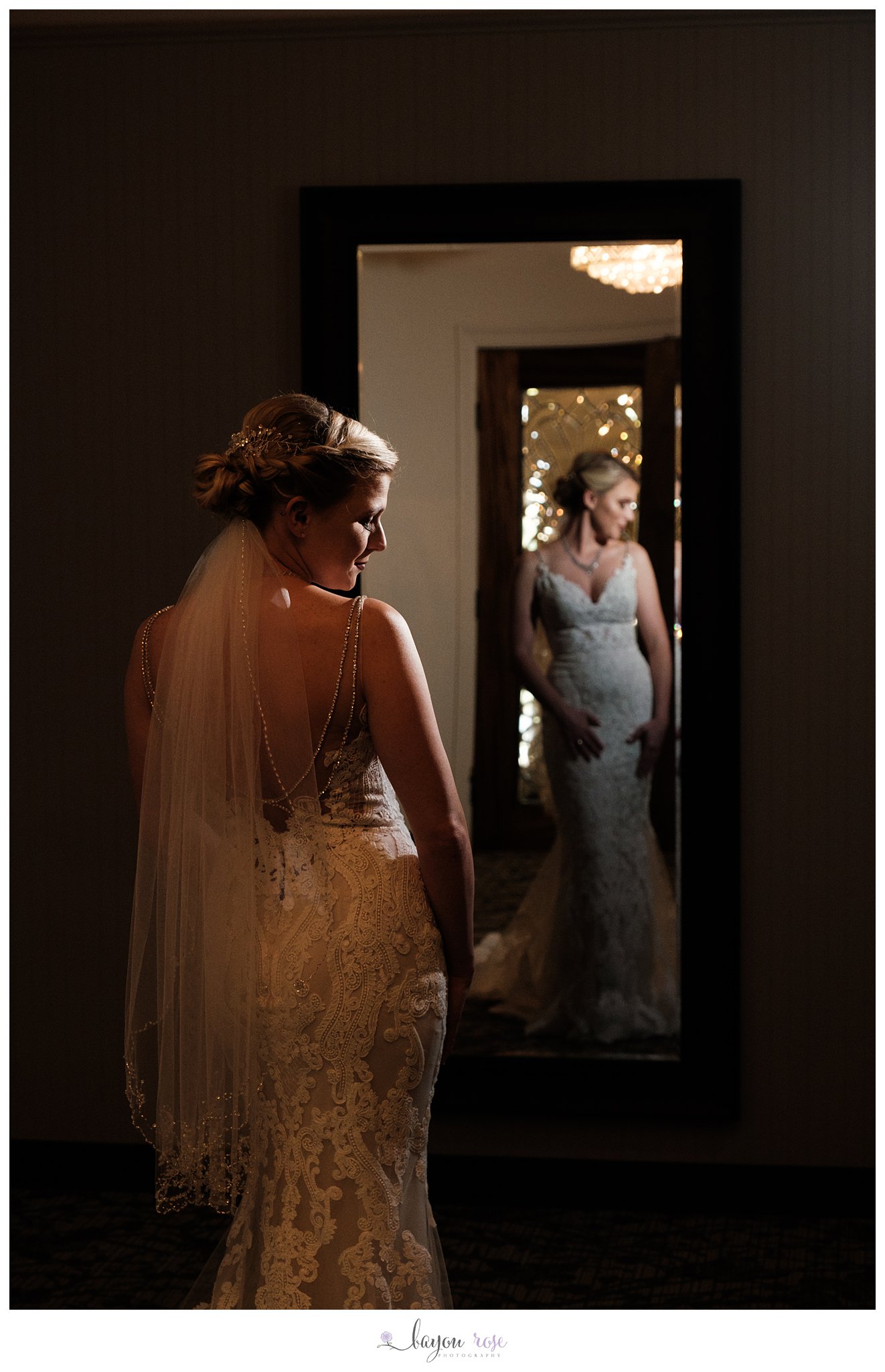 Bride highlighted in light under chandelier