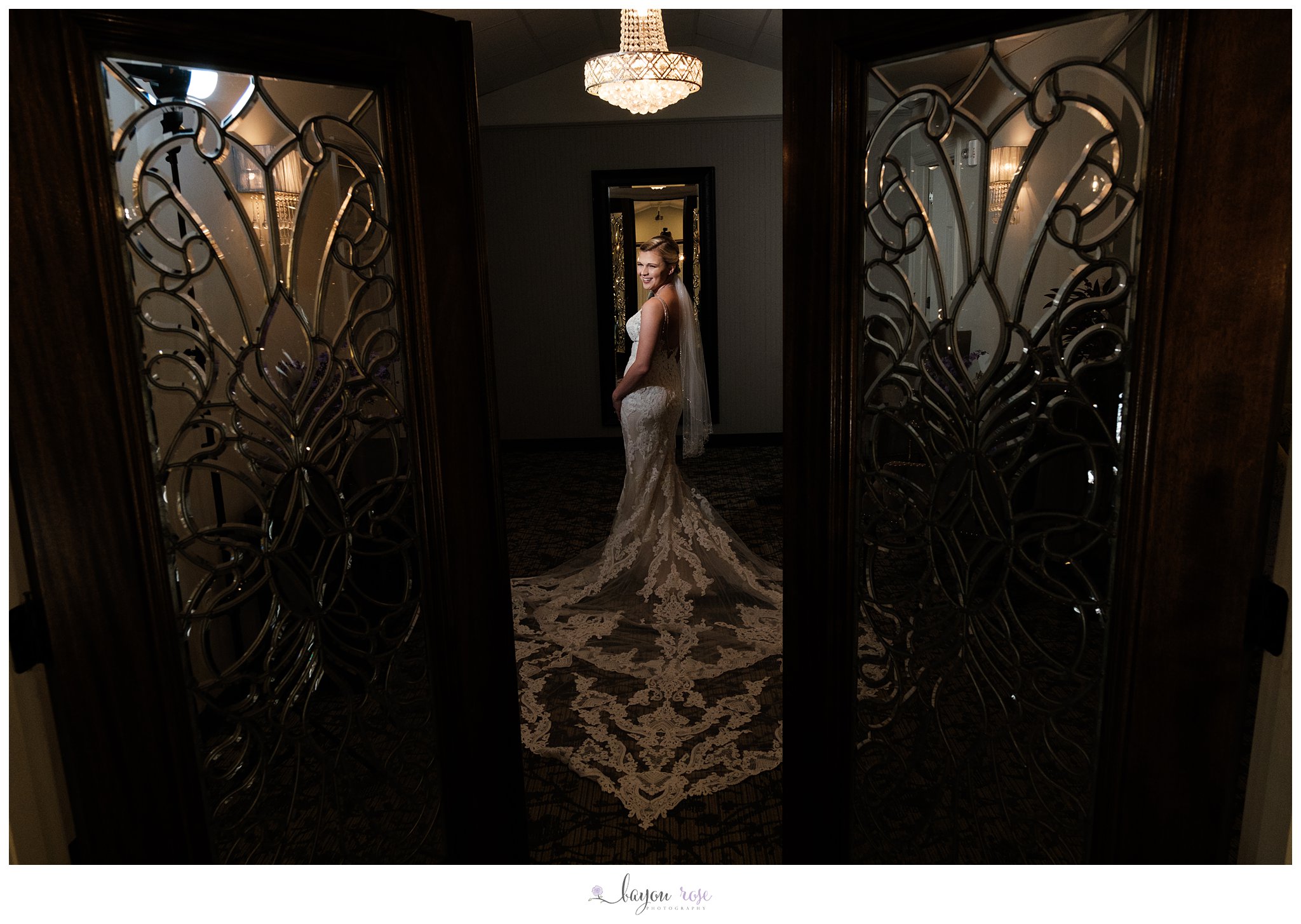 Bride laughing while framed in cut glass doors