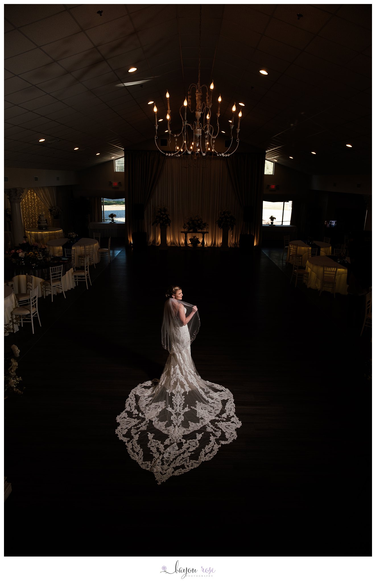 Bride in venue hall under chandelier at The Oaks