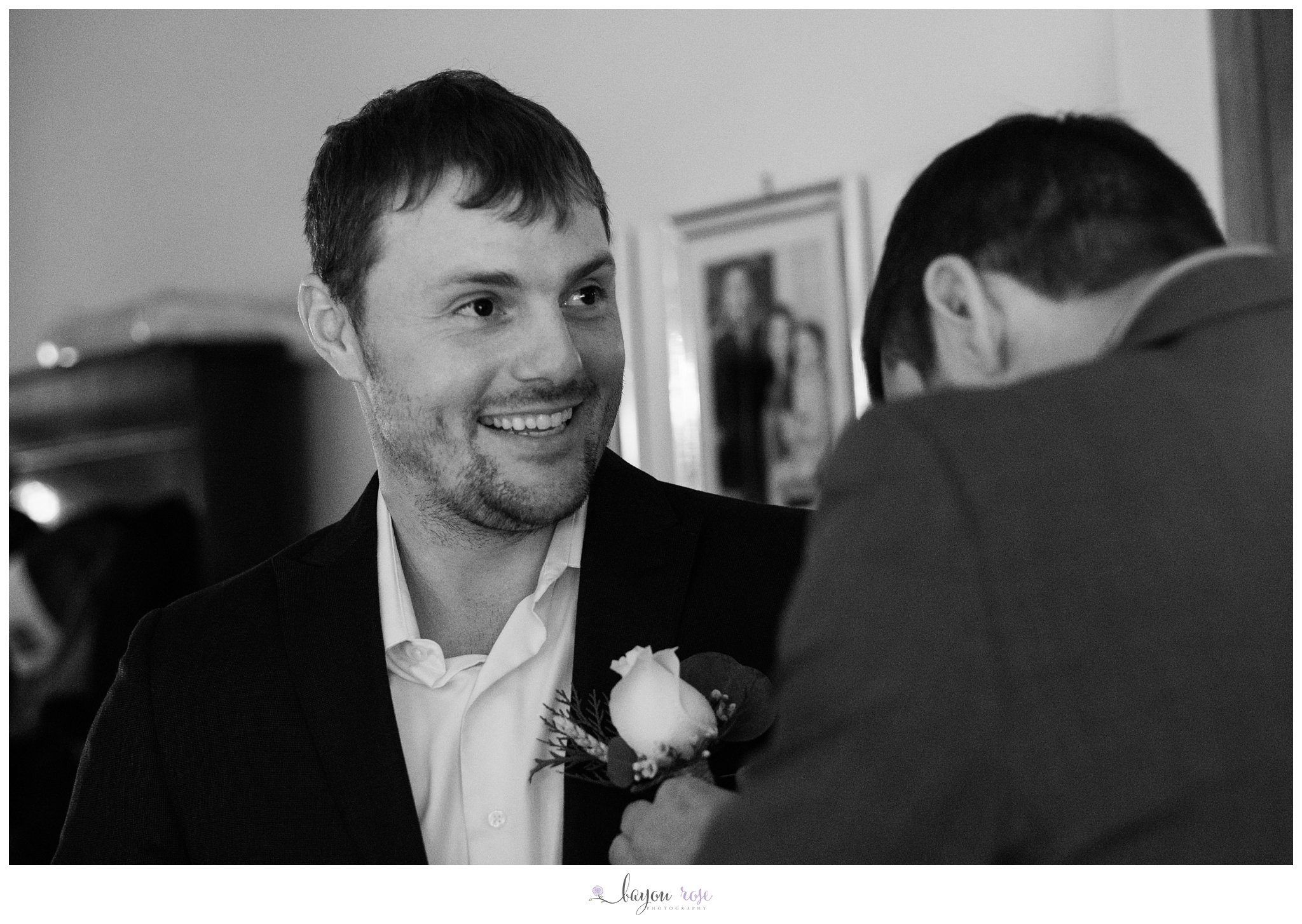 Groom getting boutonniere pinned on wedding day