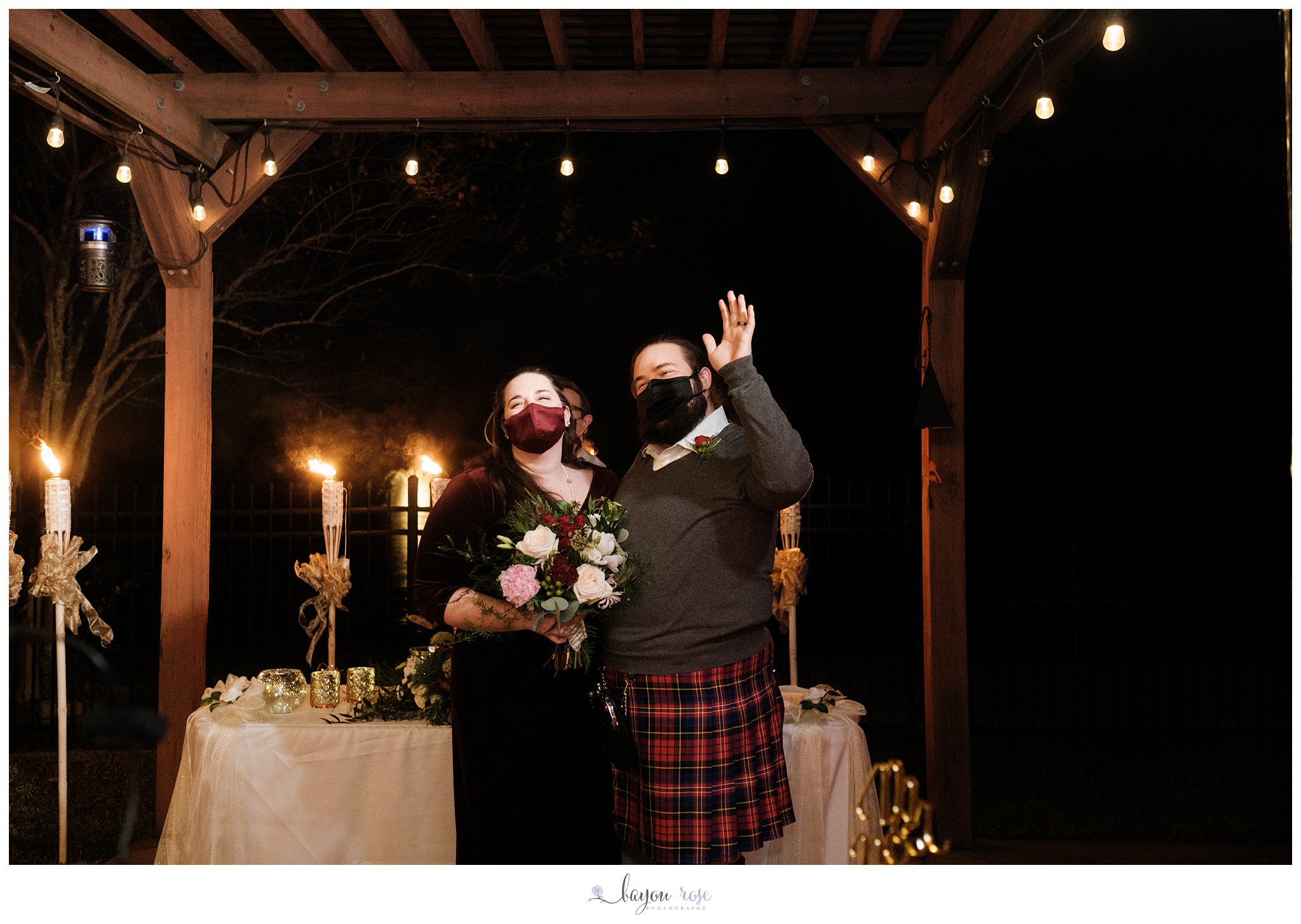 bride and groom wave to guests watching elopement from inside