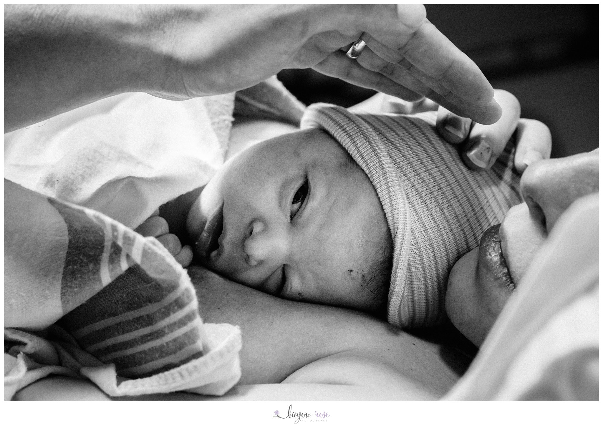 newborn baby peeking at his dad after birth at Woman's Hospital Baton Rouge