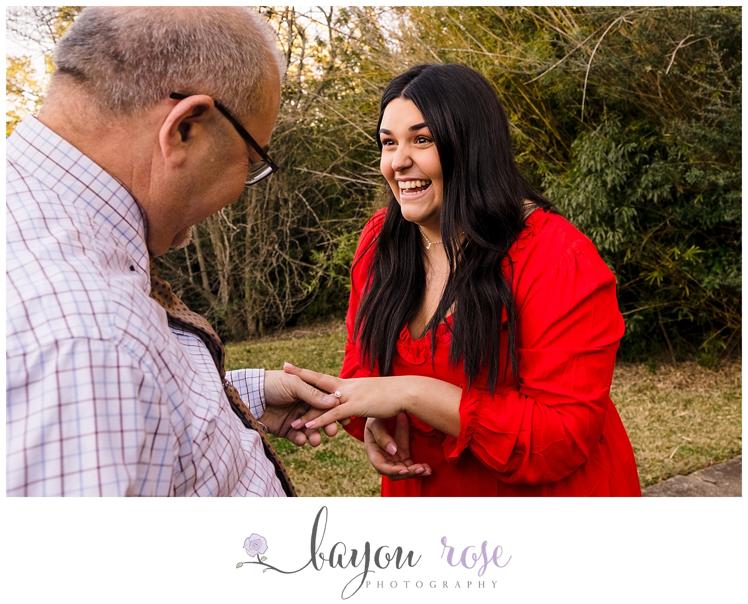 newly engaged woman showing off her ring to her father
