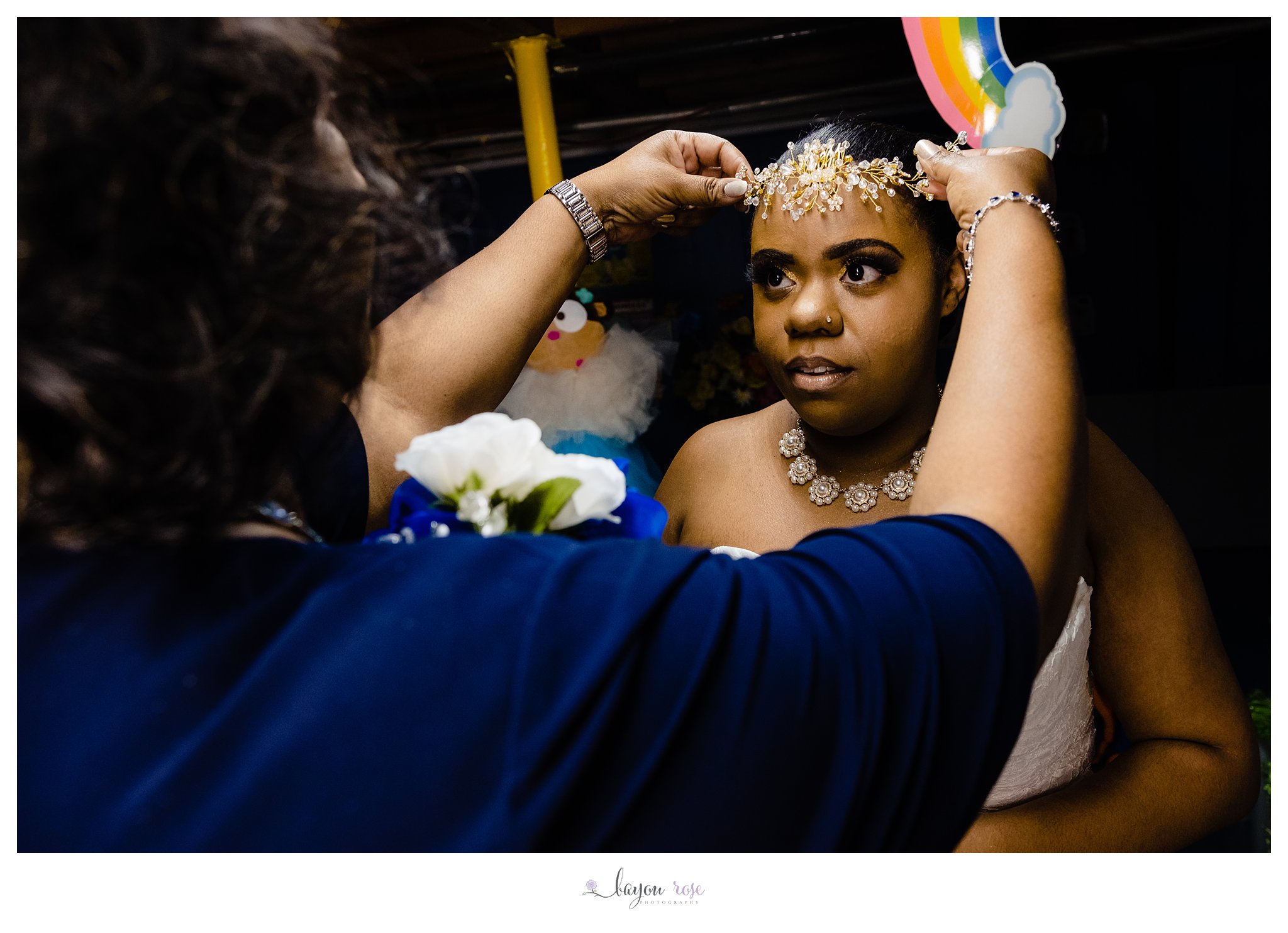 bride putting on headpiece before wedding