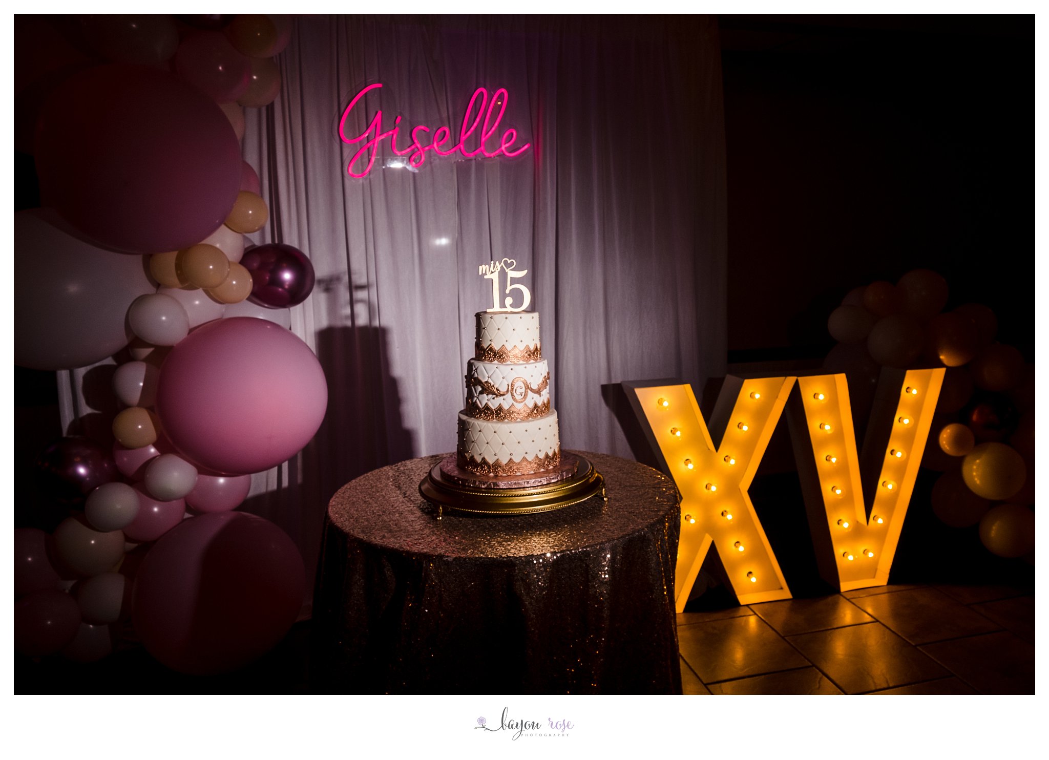 Quinceanera cake, with the birthday girl's name up in lights behind it