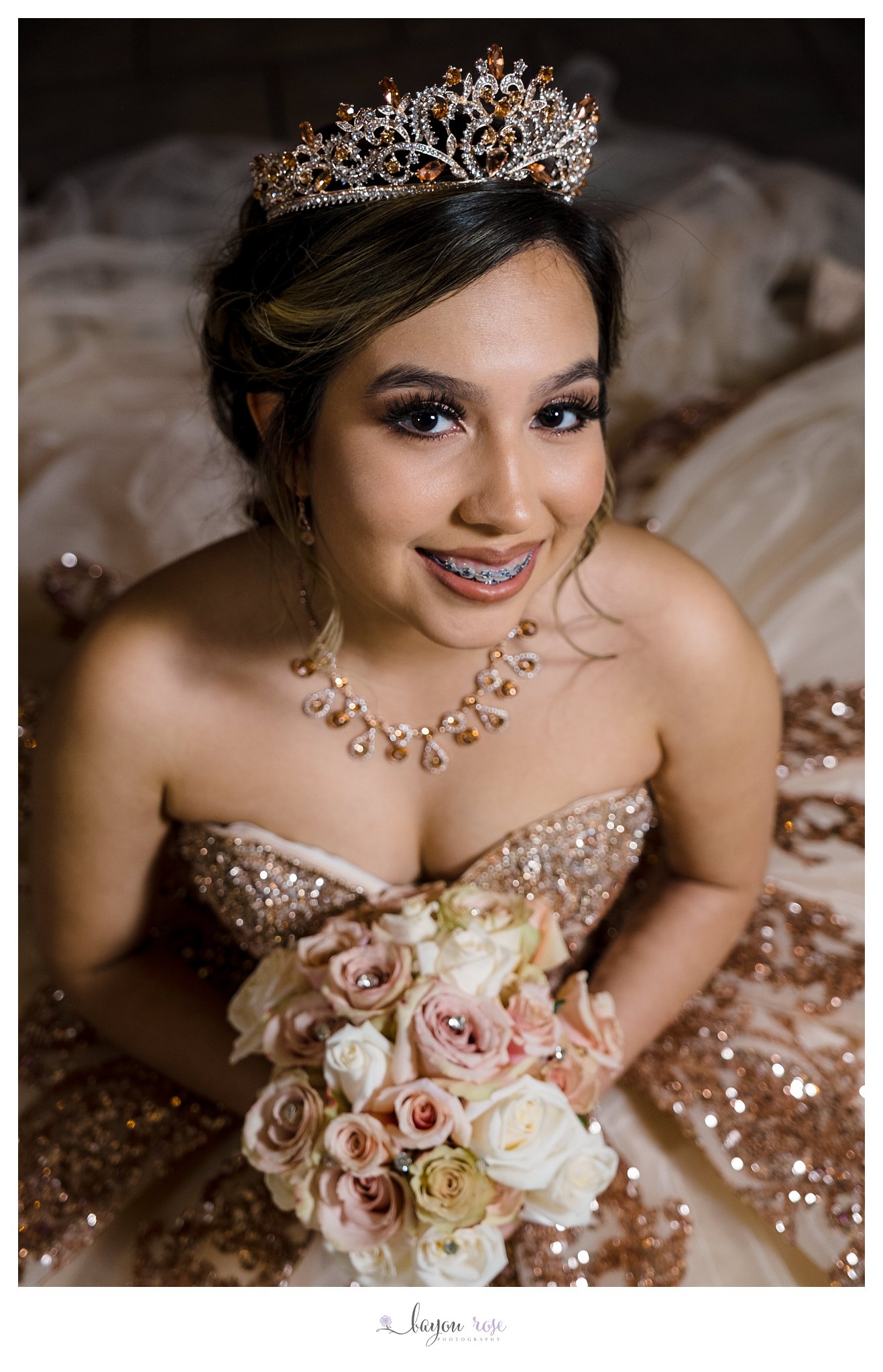 closeup of quinceanera in a crown and dress holding bouquet