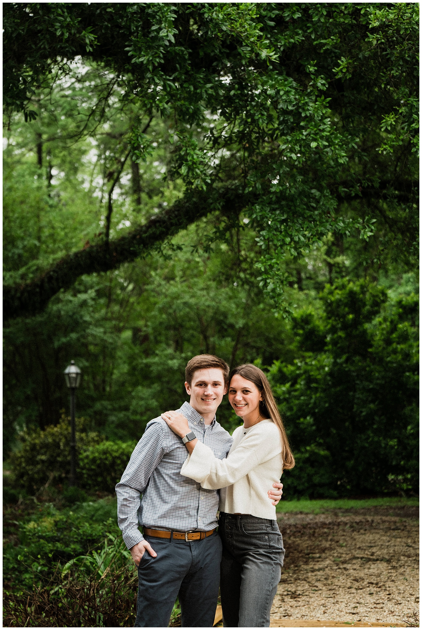 Newly engaged couple poses for photo under oak tree at Windrush Gardens Baton Rouge