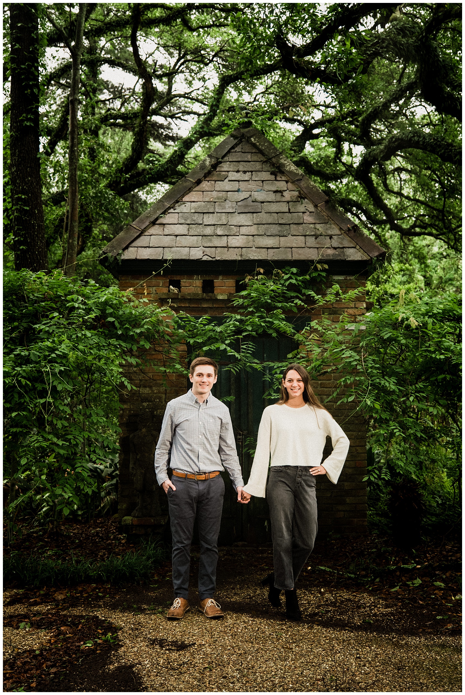 Couple posing in front of cottage after surprise proposal photography session in Baton Rouge