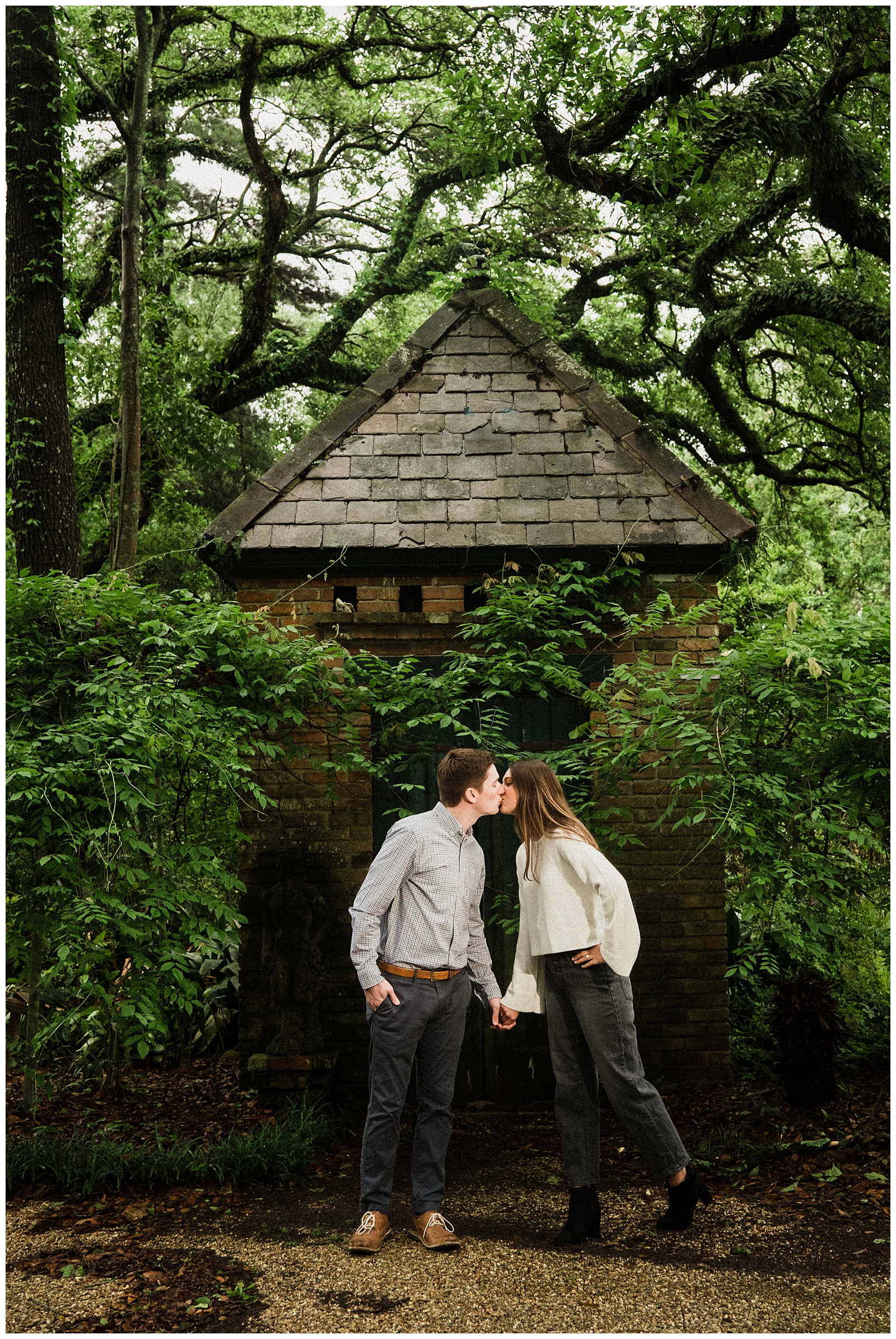 Couple kissing in front of ivy covered cottage at Windrush Gardens