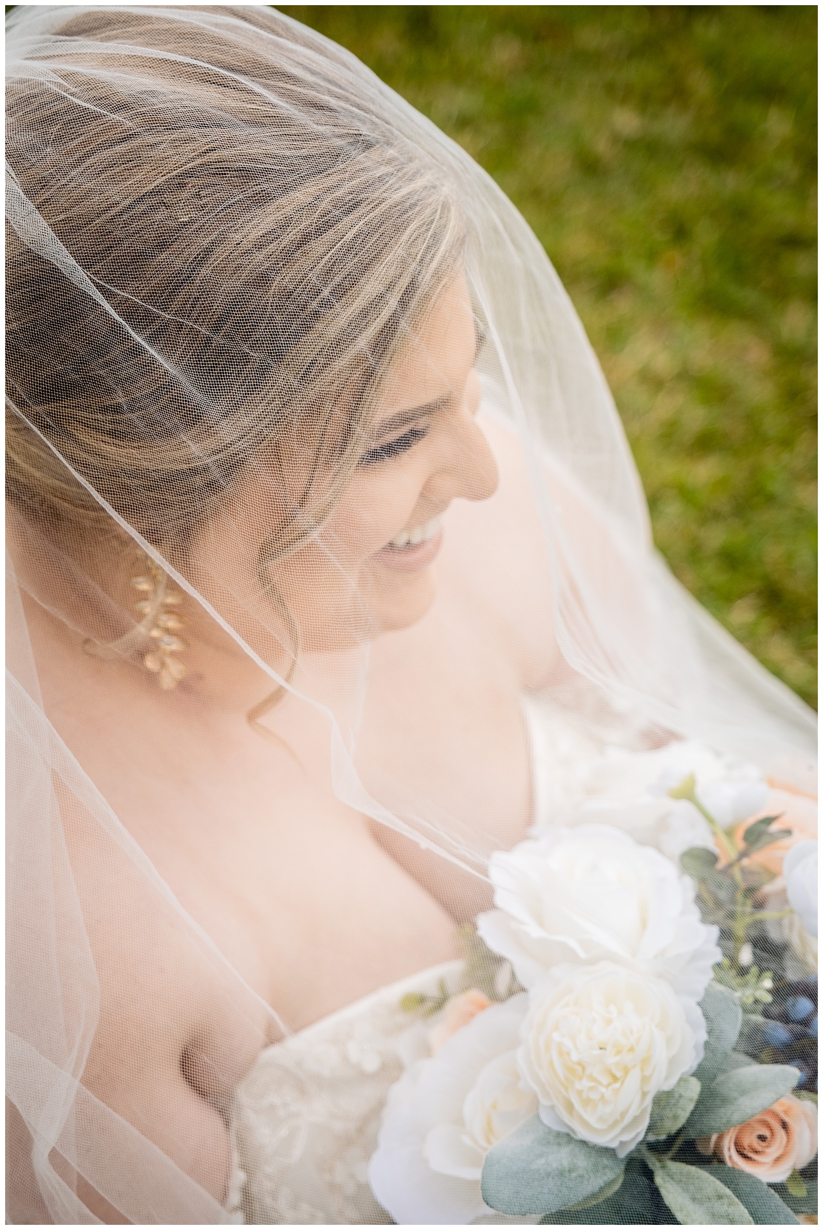 bride laughing under wedding veil for portrait photo at Barton Arboretum Trail