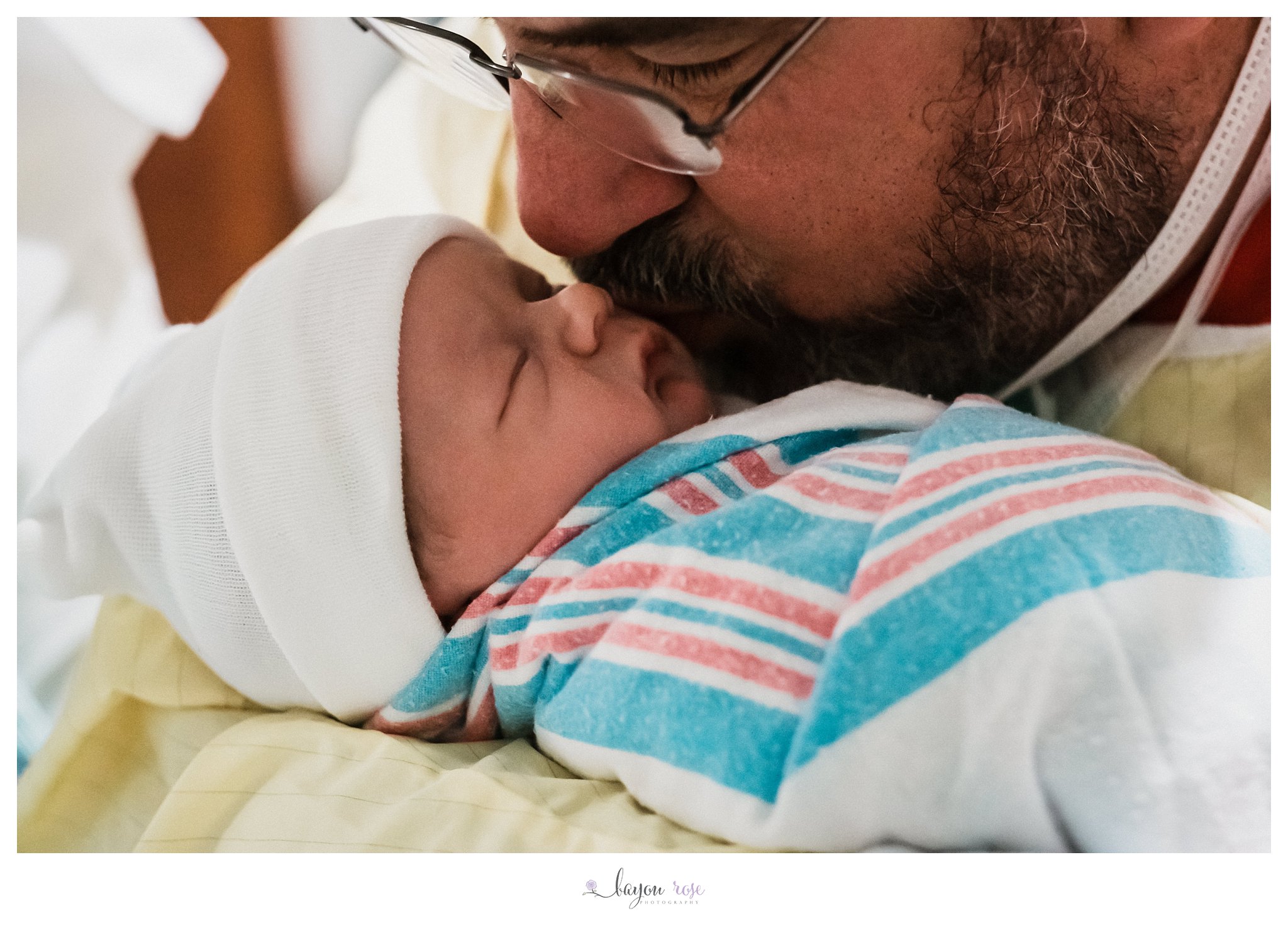 father kisses newborn daughter
