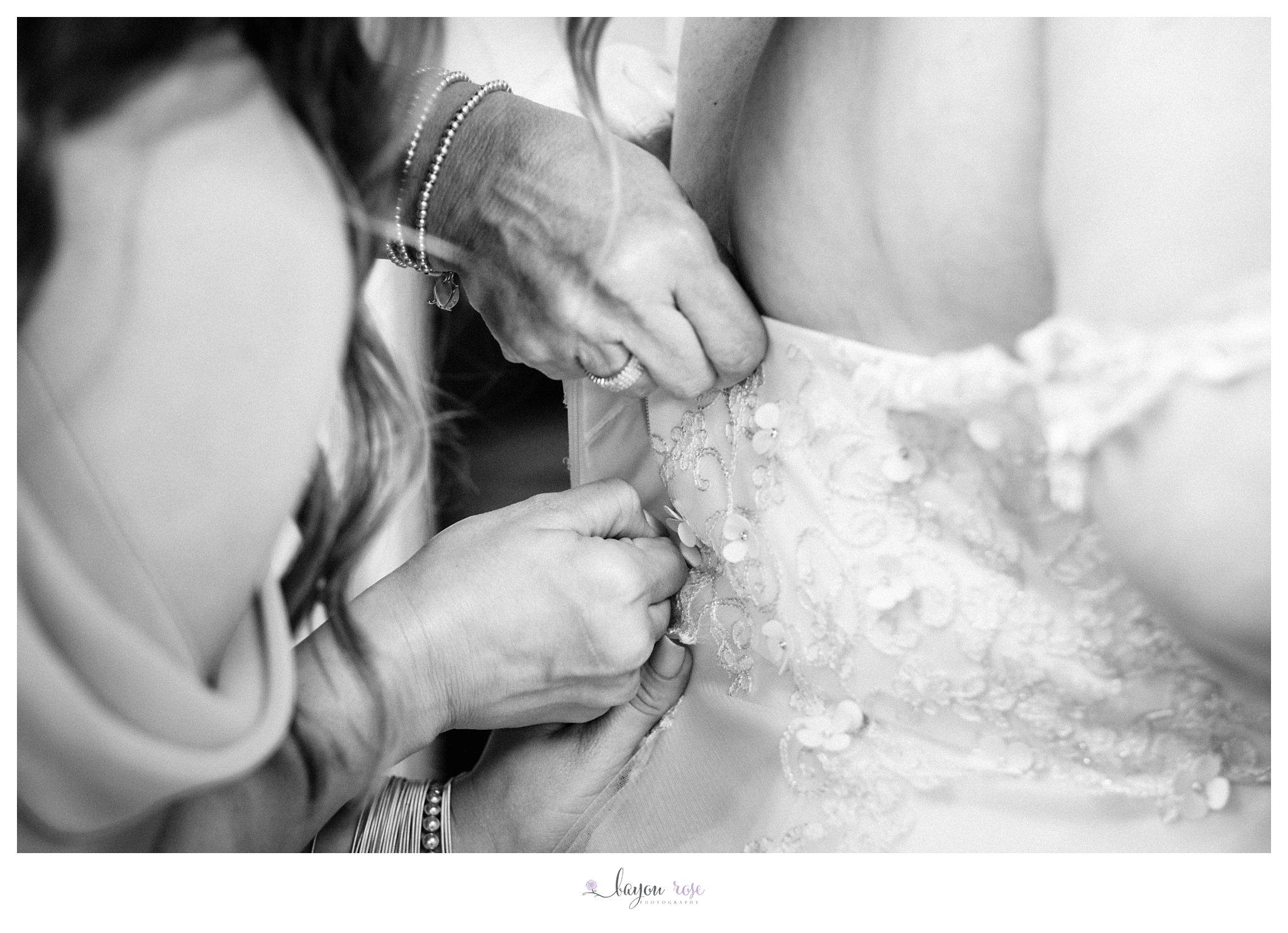 bride being zipped into her wedding dress