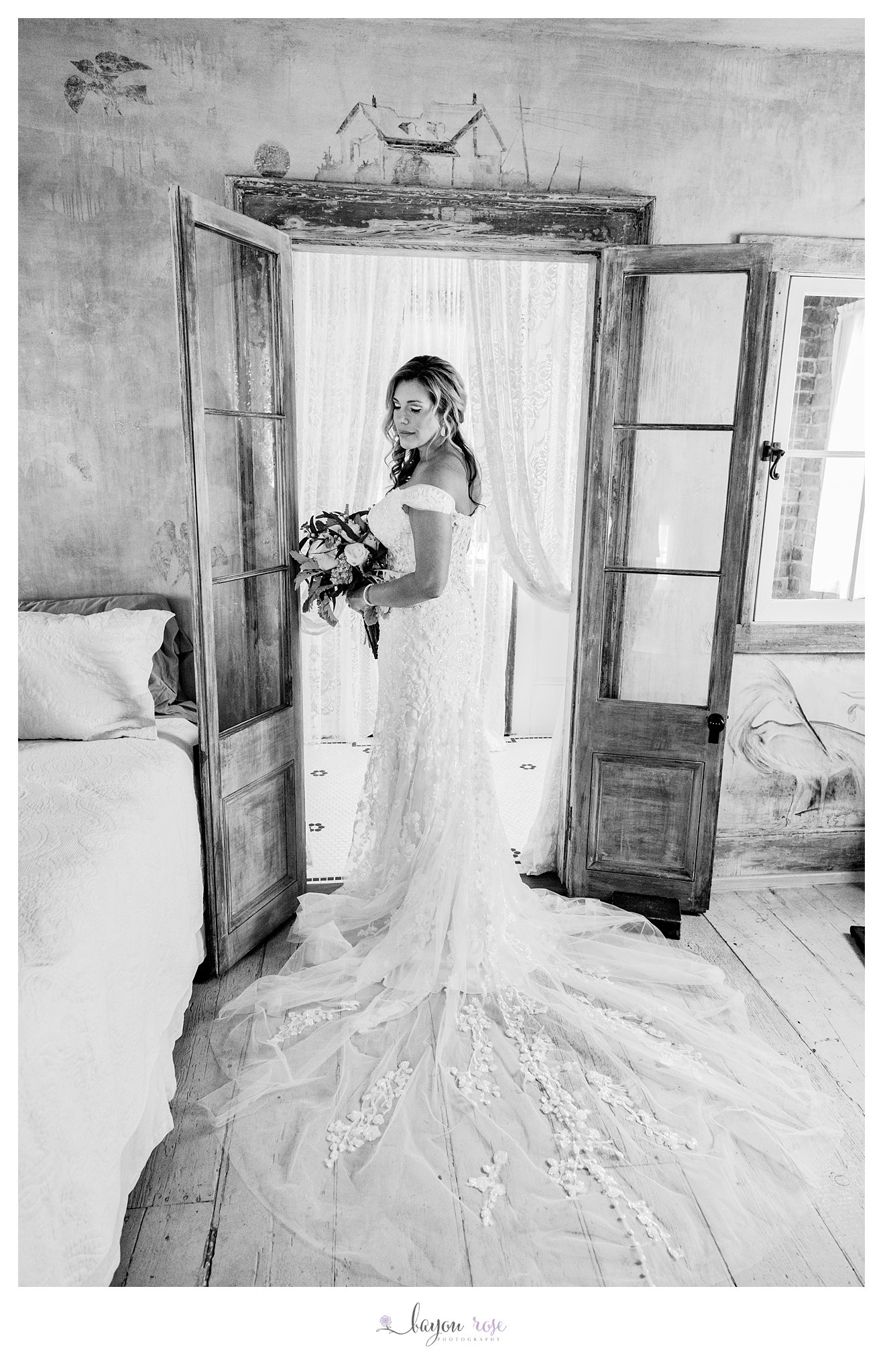 black and white photo of bride in rustic wooden doorway