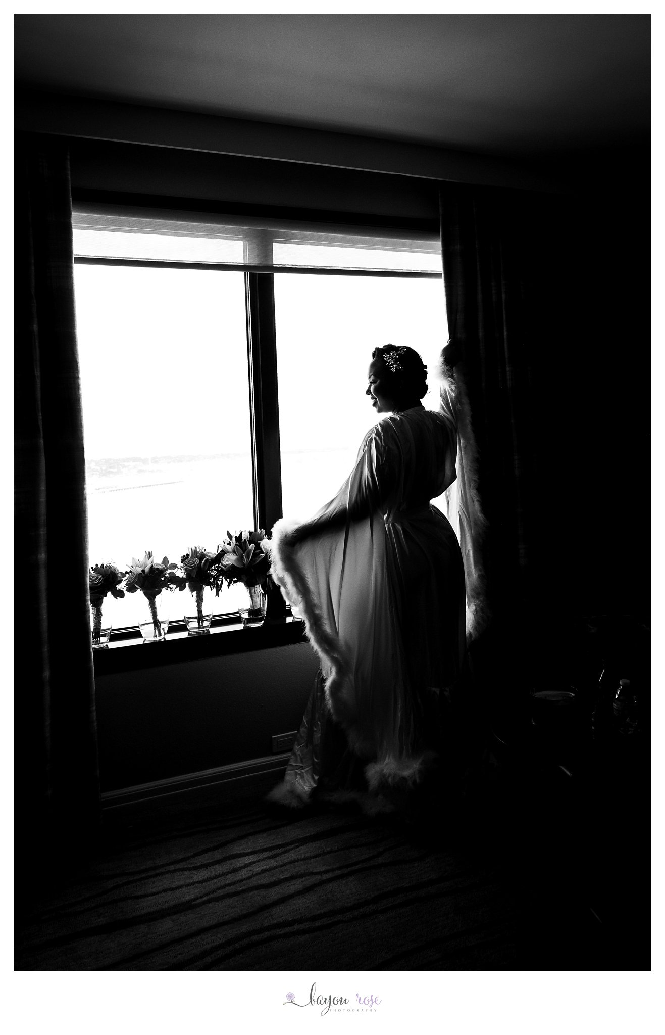 black and white photo of bride in window